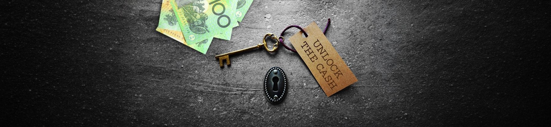 A key and Australian banknotes beside a tag reading Unlock The Cash.