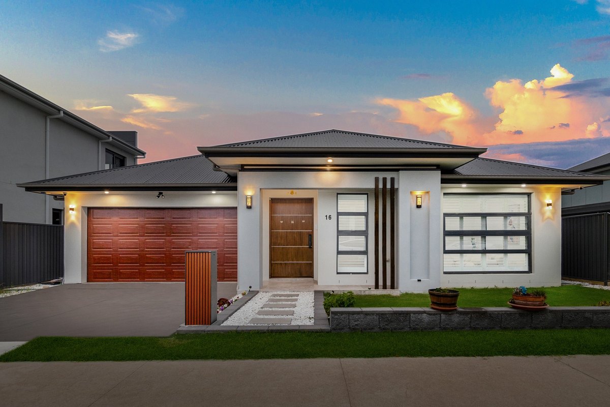 16 Olea Street, Marsden Park: a single-storey home with a double garage and landscaped front path at dusk.
